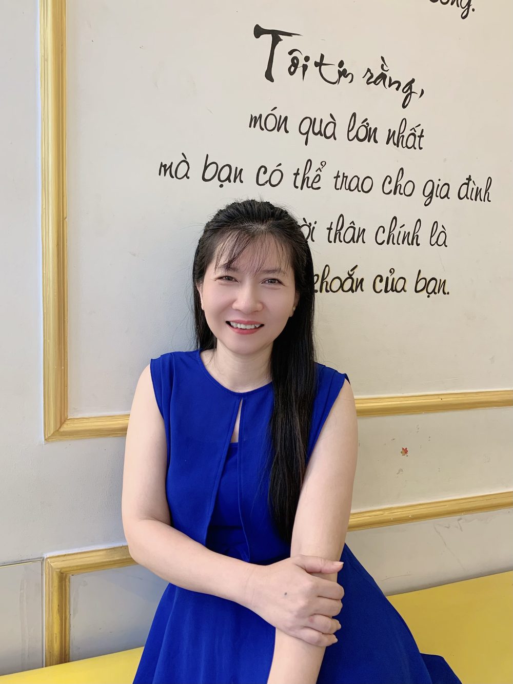 Trần Tống Thanh Tâm bên câu thư pháp trên tường Spa Cát Tiên
